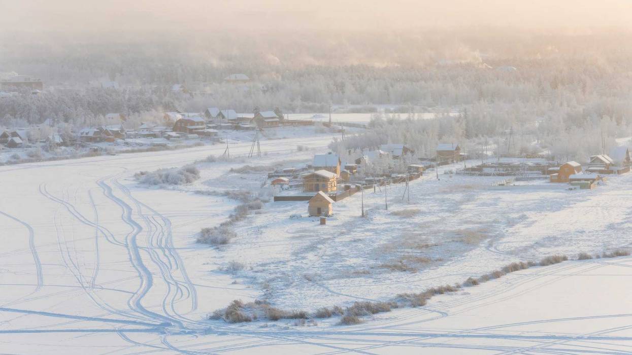 View from the hill to the Yakutsk city in the fog on a cold winter evening.