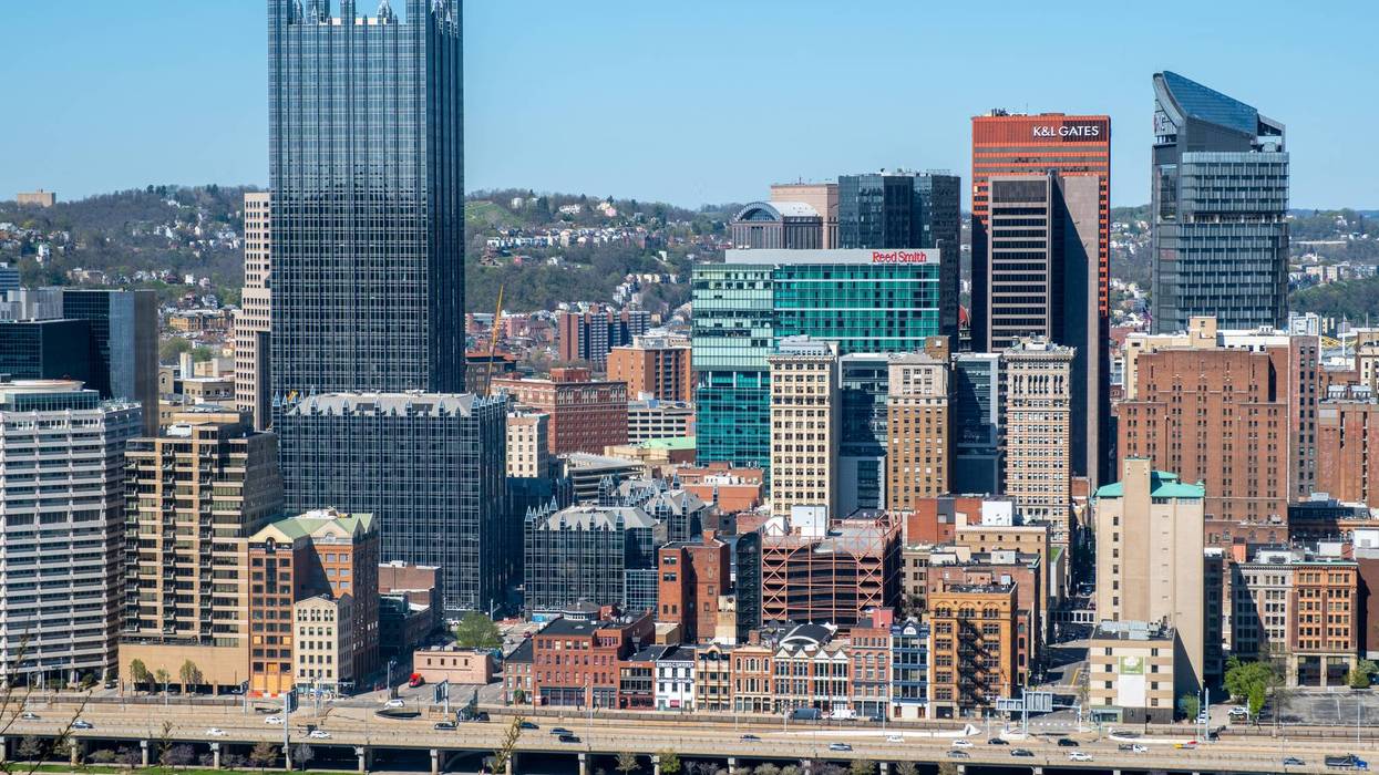 View of Pittsburgh skyline with buildings and bridge along the river on a clear day
