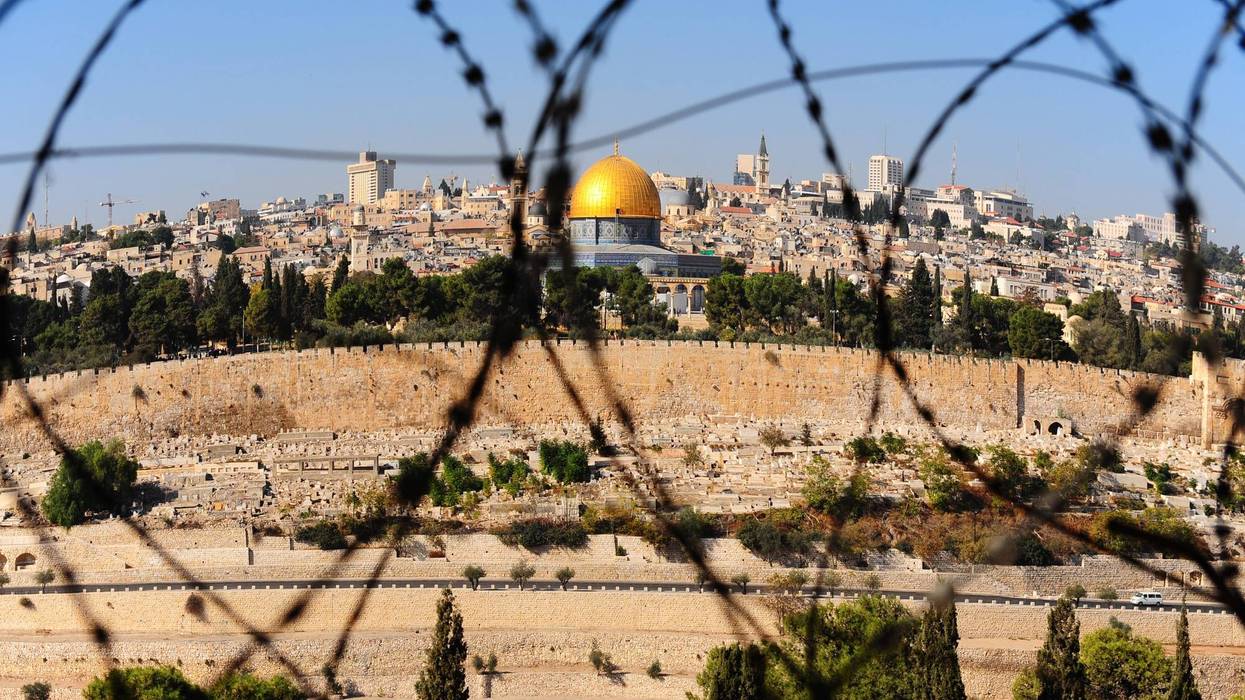 View of the dome of the rock from the Mount of Olives through barbed wire.