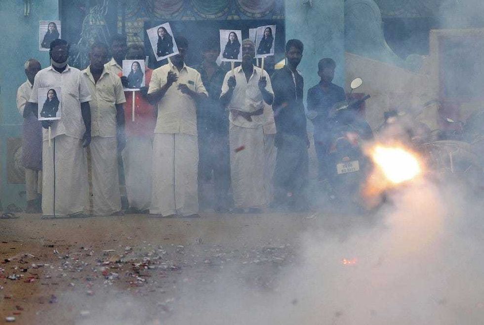 Villagers burst firecrackers and hold placards featuring U.S. Vice President-elect Kamala Harris ahead of her inauguration, in Thulasendrapuram, the hometown of Harris