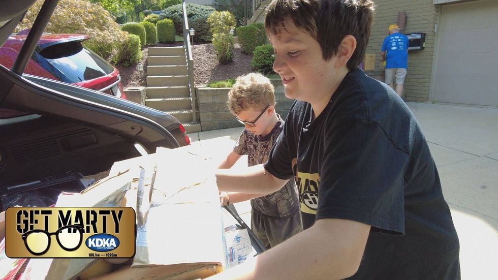 Vince Griffin and Eli Gerhardt help load boxes of balls into Marty
