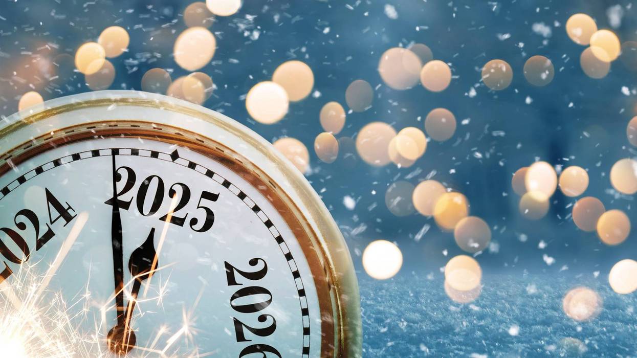 Vintage clock points to the new year 2025 on a beautiful winter background with golden lights bokeh and sparks at evening.