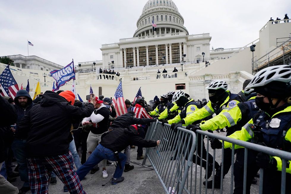 Violent insurrections loyal to President Donald Trump try to break through a police barrier at the Capitol in Washington on Jan. 6, 2021.