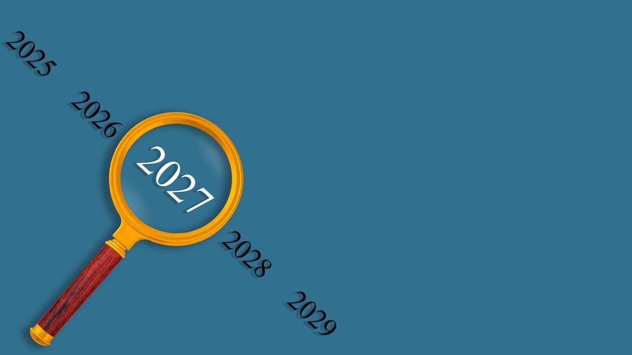 Vision 2027 concept with magnifying glass on blue background, looking into the future