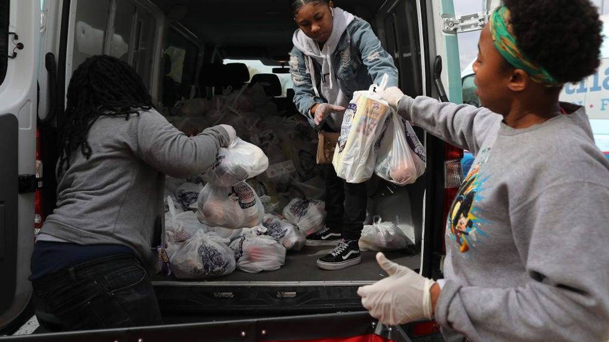 Volunteers for nonprofit organization Martha's Table Chantasia Beatty, Kiara Brown and Stephanye White load bags of fresh produce to distribute to people in underserved communities during the novel coronavirus outbreak April 01, 2020 in Washington, DC.