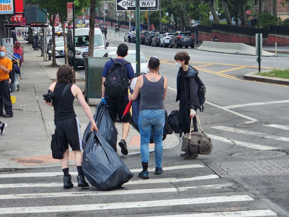 Volunteers help camp residents haul off belongings so they are not destroyed in the sweep.