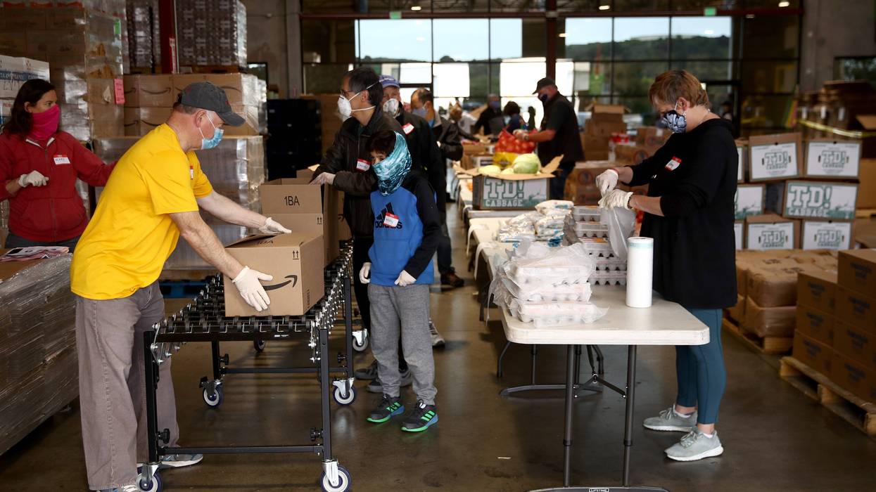 Volunteers pack boxes full of food at the San Francisco-Marin Food Bank on April 18, 2020 in San Rafael, California.