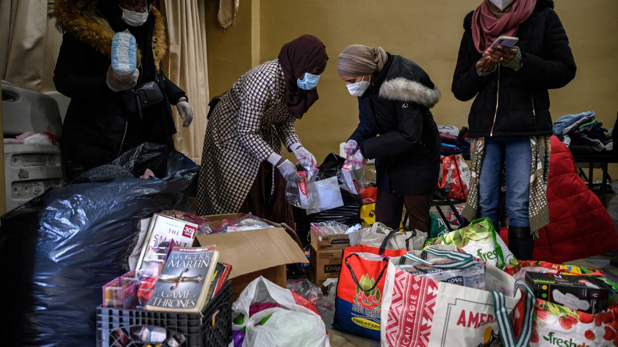 Volunteers prepare donations of clothes, food, and other items for people displaced by a fire at an apartment building nearby in the Bronx, New York on January 10, 2022