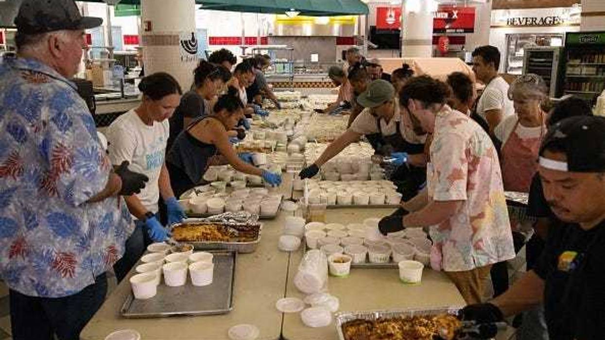 Volunteers prepare free meals to donate to West Maui families affected by wildfires, at the University of Hawaii Maui College in Kahului, Maui