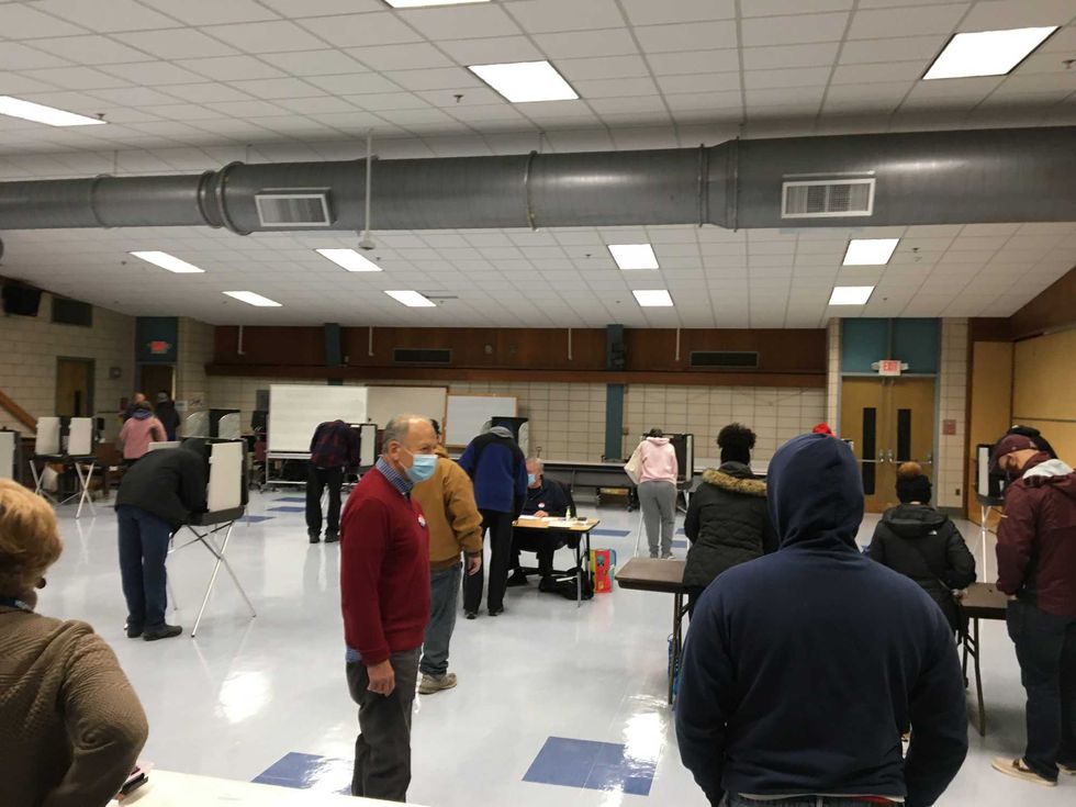 Voters get ready to enter Charter Oak International Academy after spending nearly an hour in line.
