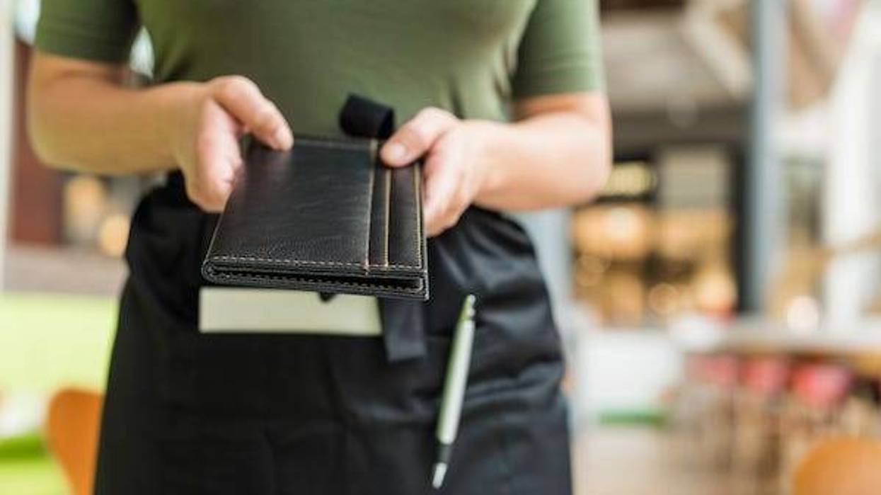 Waitress holding out a bill for customers