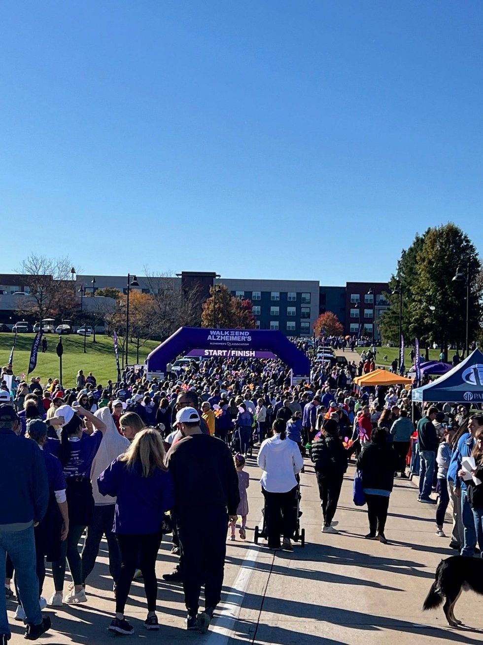 Walkers go through a starting gate at the 2024 St. Louis Walk to End Alzheimer