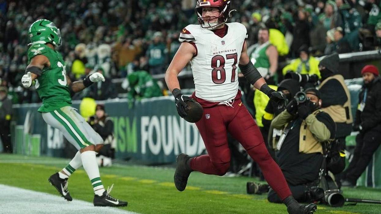 Washington Commanders tight end John Bates (87) scores a touchdown in front of Philadelphia Eagles linebacker Jihaad Campbell (30) during the second half of an NFL football game on Sunday, Jan. 4, 2026, in Philadelphia.