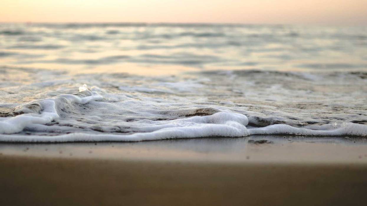 Water approaching shore on a beach.