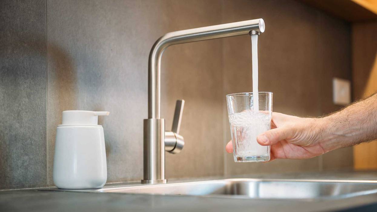 Water from a faucet going into a drinking glass