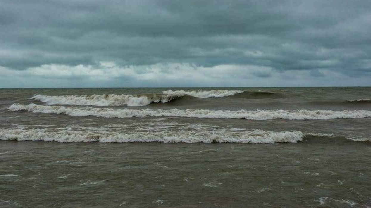 Waves crashing the beach of Lake Michigan with cloudy skies