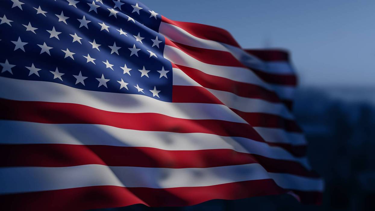 Waving United States flag with detailed texture and lighting against a soft blue background, symbolizing patriotism and national pride concept. 3D Rendering