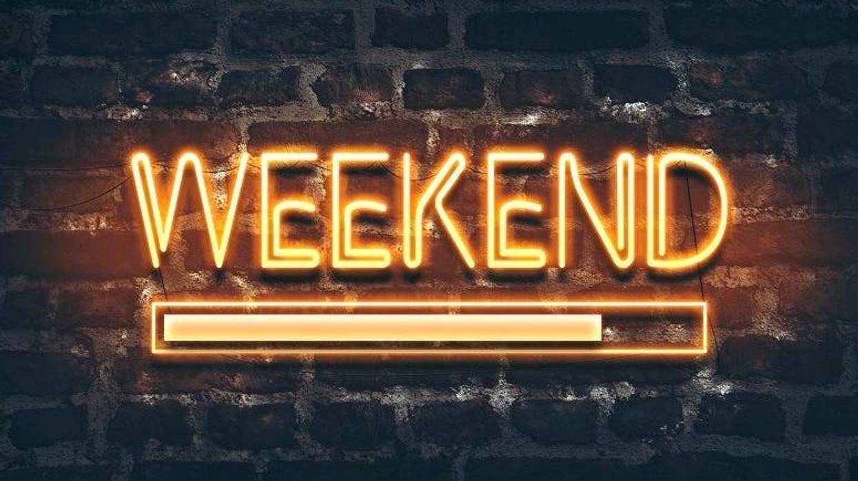 Weekend loading neon sign on dark brick wall background