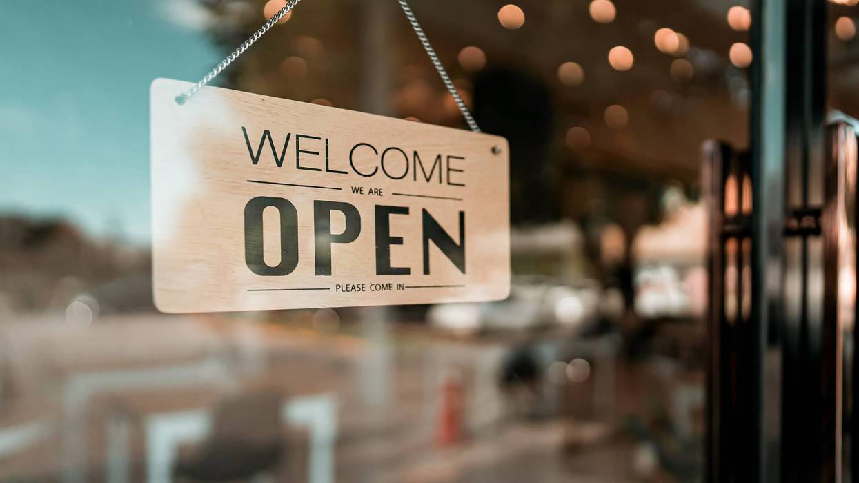 welcome we are open sign on a window