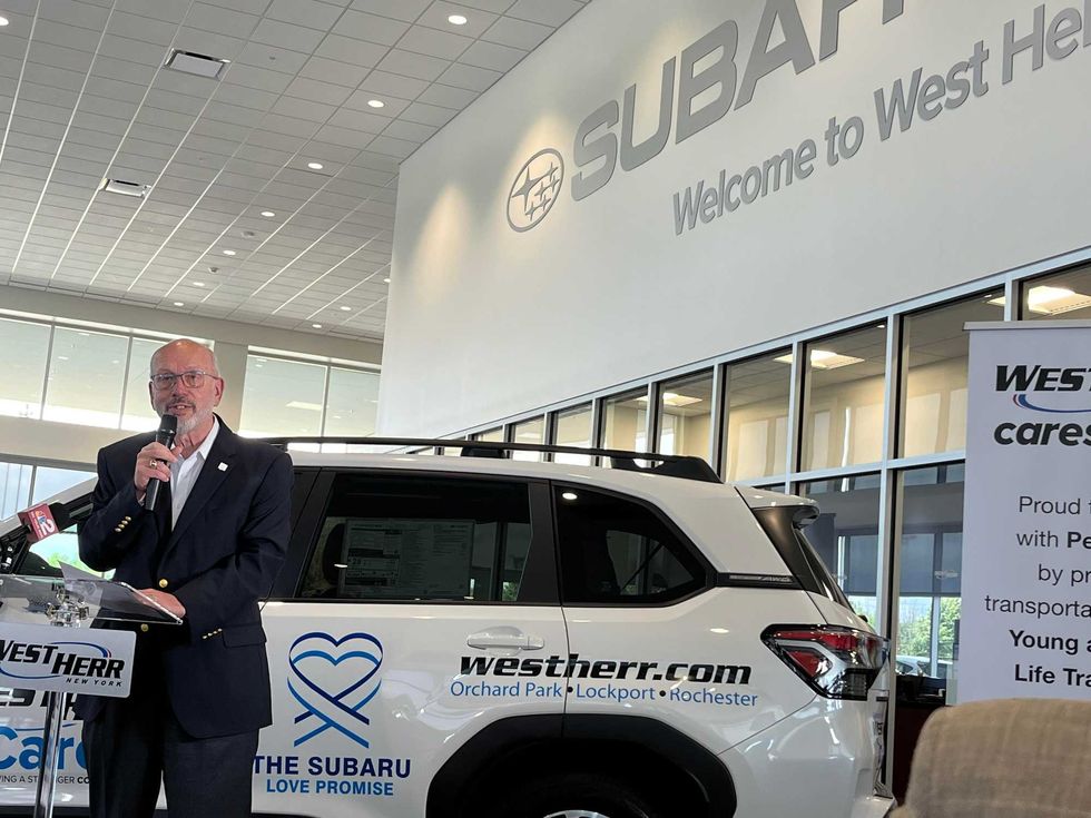 West Herr CEO Scott Bieler standing in front of the 2025 Subaru Forester which was donated to People, Inc.