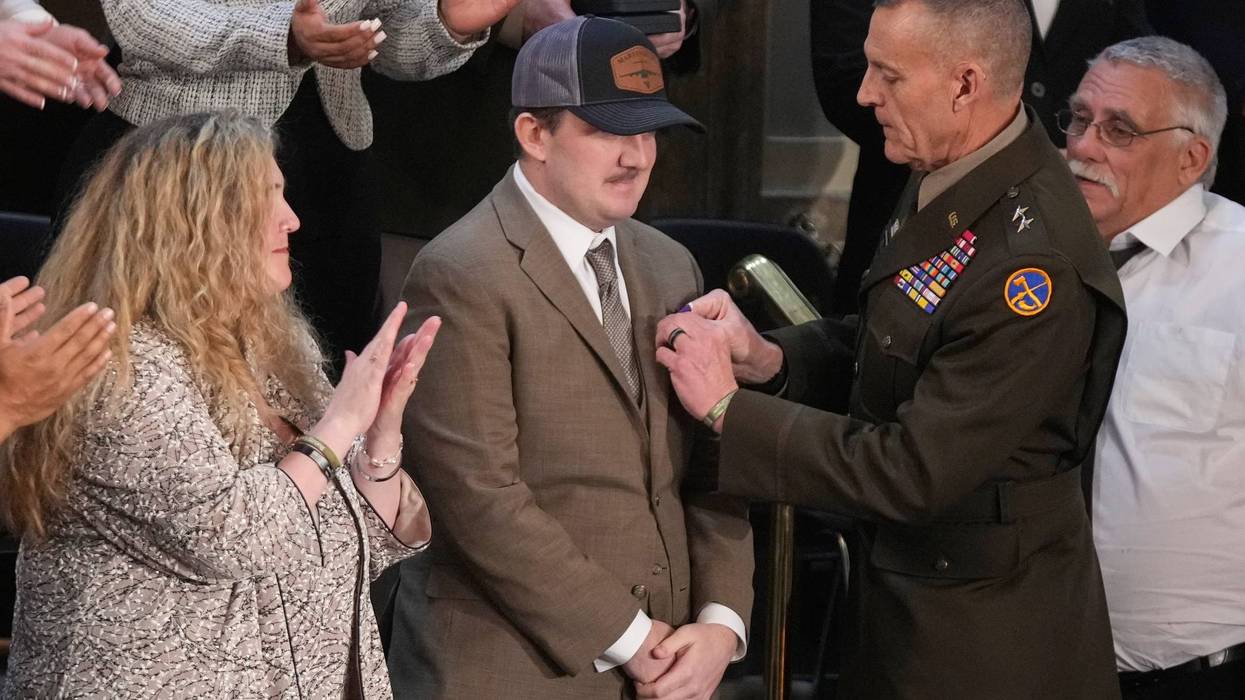 West Virginia National Guard Staff Sgt. Andrew Wolfe receive the Purple Heart as his mother, Melody, watches during President Donald Trump's State of the Union address to a joint session of Congress in the House chamber at the U.S. Capitol in Washington, Tuesday, Feb. 24, 2026.