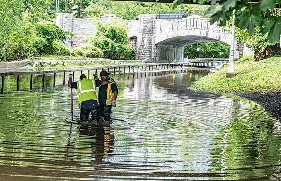 Westchester County Department of Public Works employees clear clogged drains on the flooded Bronx River Parkway in White Plains on July 15, 2025