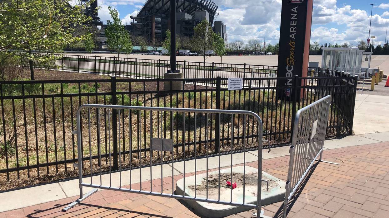 Where the statue of the late singer Kate Smith once stood at the Sports Complex in South Philadelphia there is now an empty spot with three flowers.