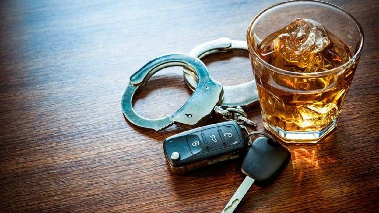 Whiskey with car keys and handcuffs concept for drinking and driving