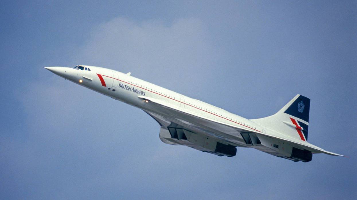 White British Airways Concorde jet taking off against a blue sky.
