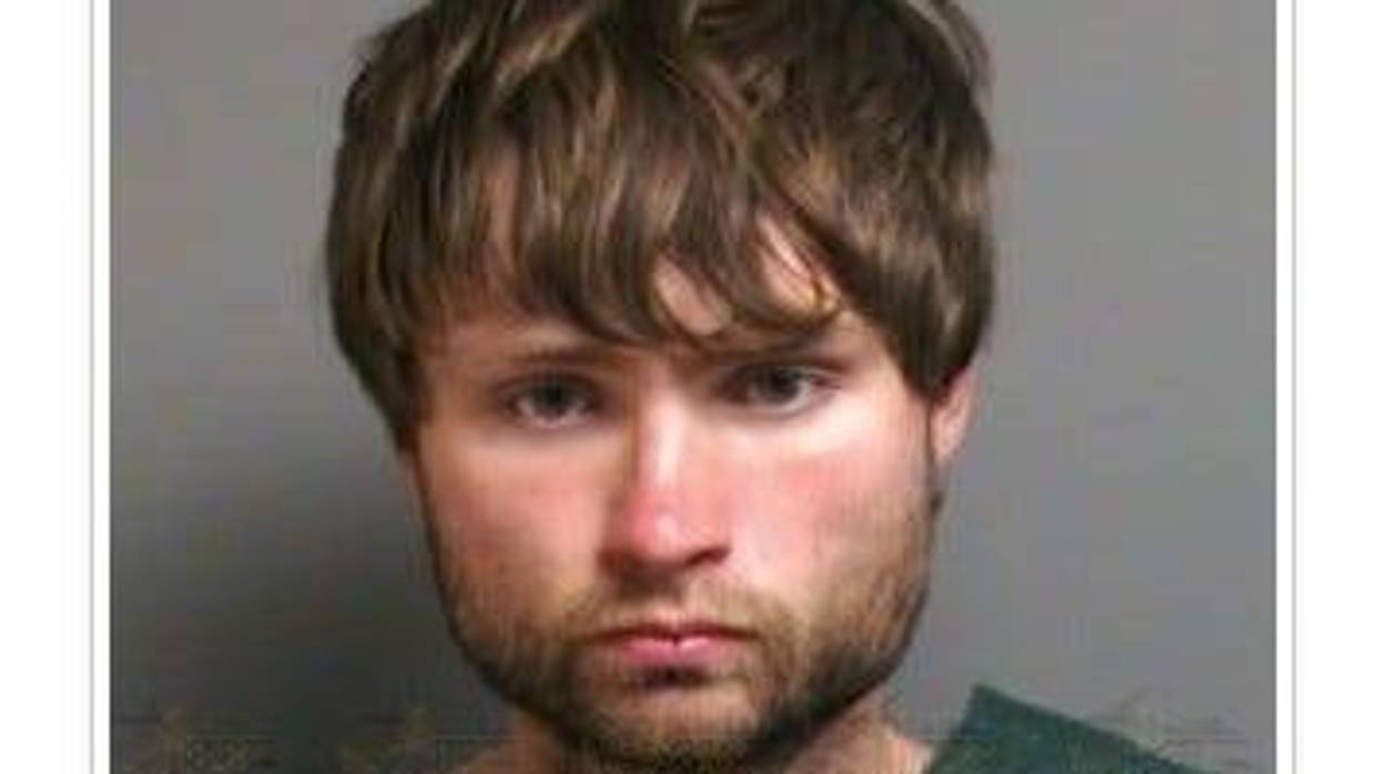 White man in 20s with shaggy brown hair and brown beard