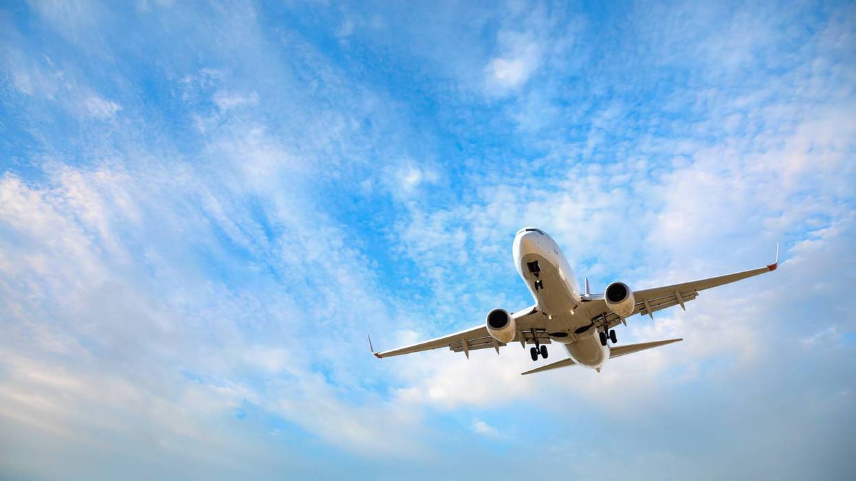 White passenger airplane flying in the sky amazing clouds in the background