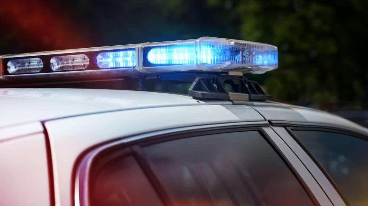 White police car's roof with blue emergency lights flashing.