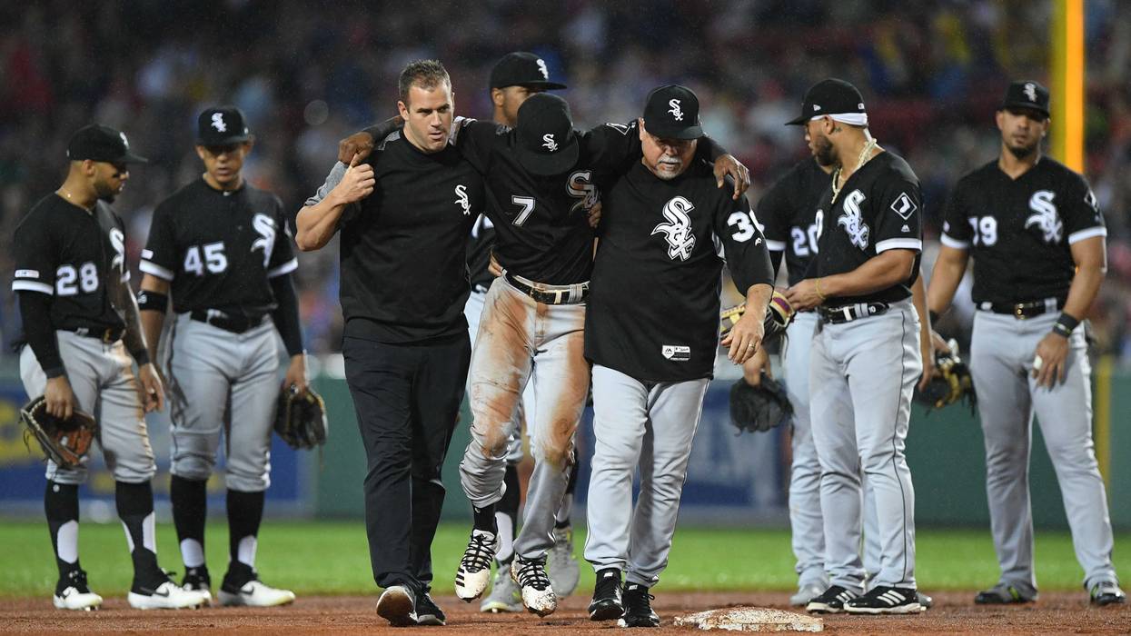 White Sox shortstop Tim Anderson (center) is helped off the after suffering an injury.