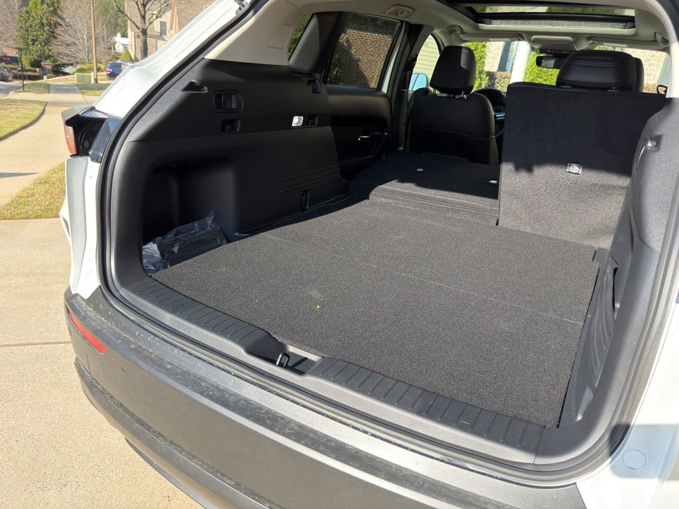 White SUV trunk interior with rear seats folded flat, creating a large, level cargo area.