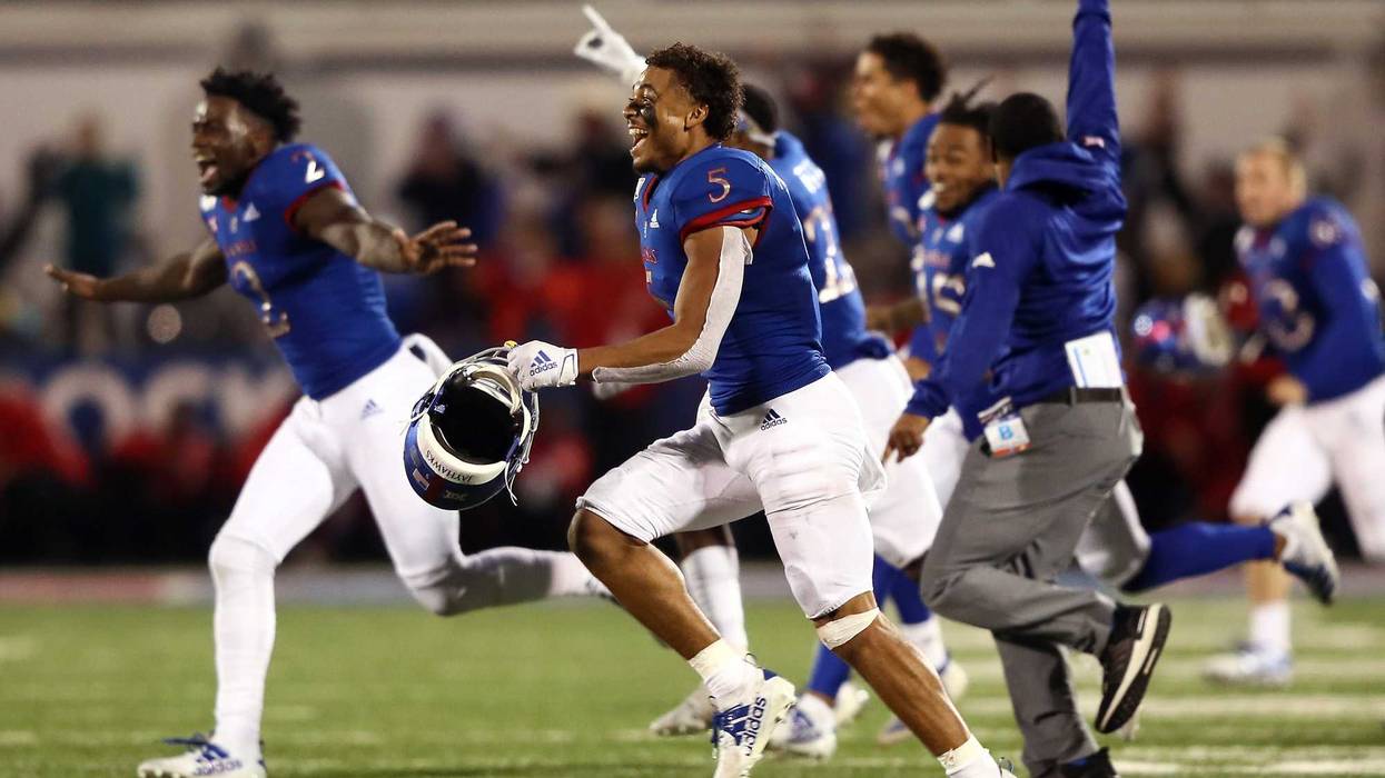 Wide receiver Stephon Robinson Jr. #5 and the Kansas Jayhawks storm the field and celebrate as they defeat the Texas Tech Red Raiders 37-34 to win the game at Memorial Stadium on October 26, 2019 in Lawrence, Kansas.