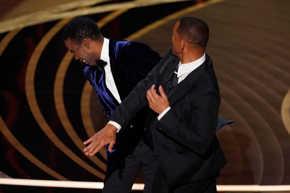 Will Smith, right, punches Chris Rock onstage during the Oscars ceremony, Sunday, March 27, 2022, at the Dolby Theater in Los Angeles