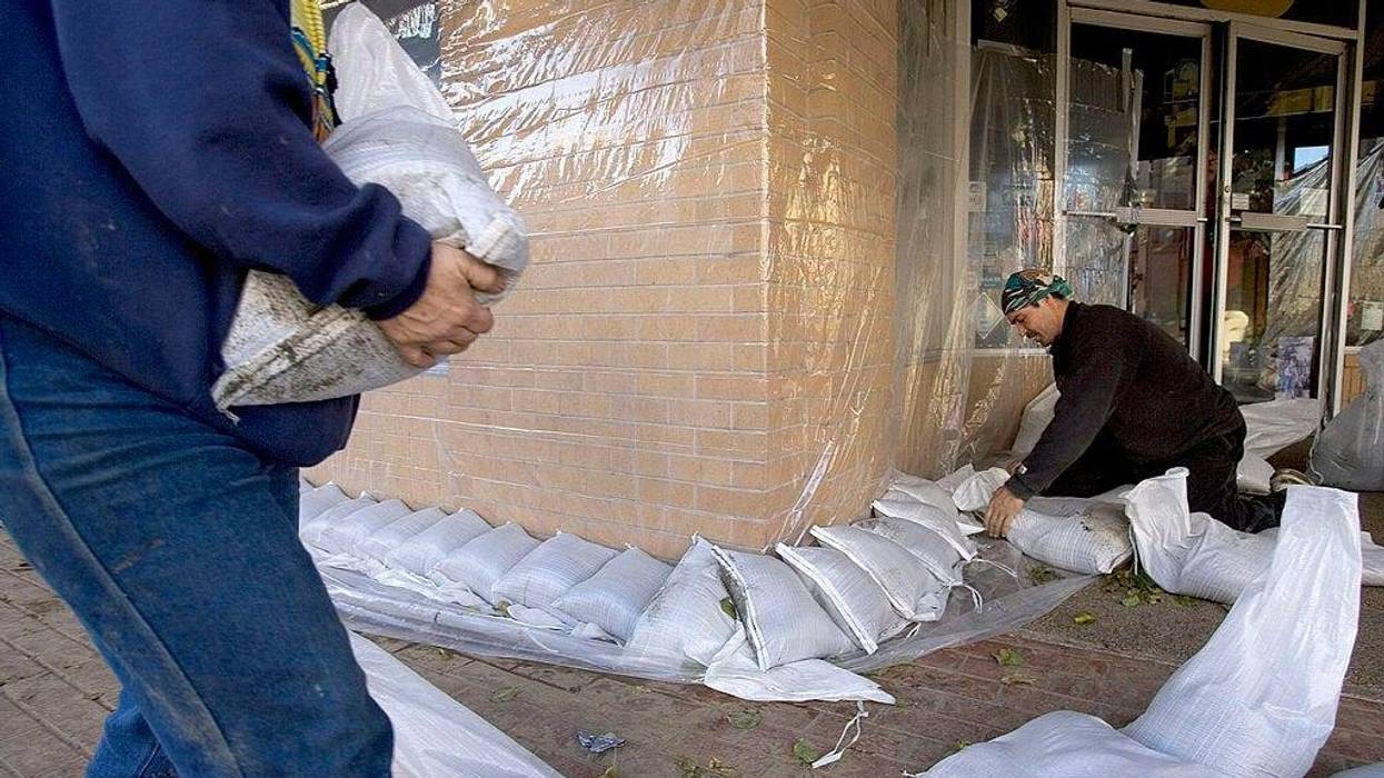 William Maxwell Coulter puts down sand bags in front of his store after a storm left much of downtown under water on December 31, 2005 in Napa, California.