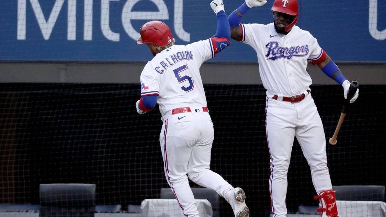Willie Calhoun #5 of the Texas Rangers celebrates with Adolis Garcia #53 of the Texas Rangers after hitting a solo home run against the Cleveland Indians in the bottom of the first inning at Globe Life Field on October 02, 2021 in Arlington, Texas.