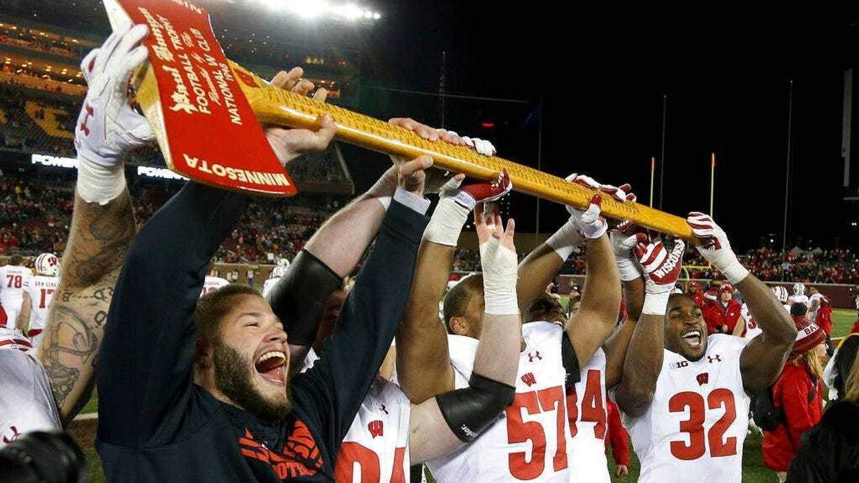 Wisconsin players hold up Paul Bunyan's Axe up after winning 31-0 against Minnesota