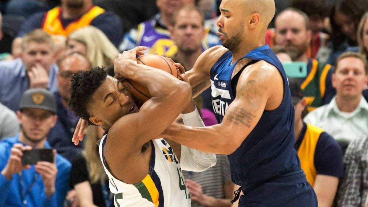Wolves guard Jerryd Bayless tries to take the ball from Donovan Mitchell