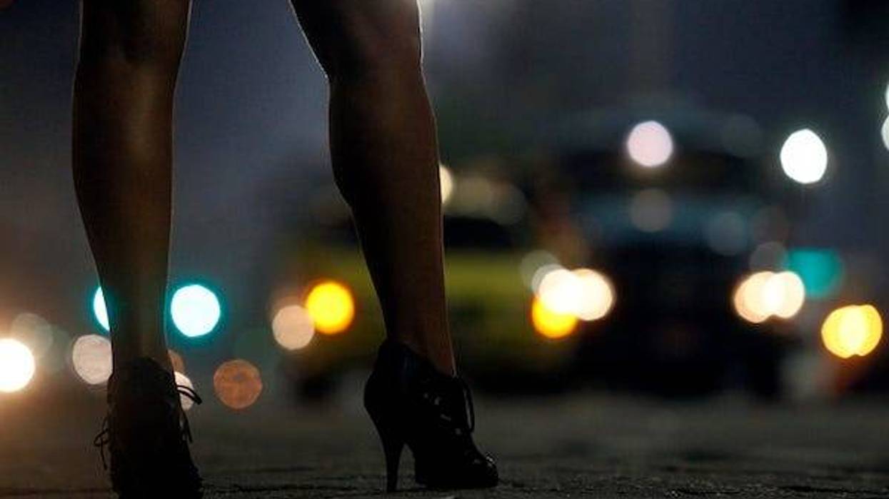 Woman at night wearing heels staring at cars
