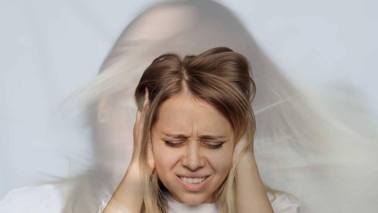 Woman covering her ears.