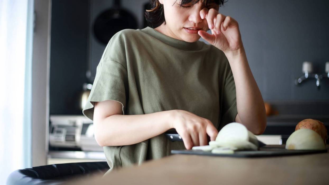 Woman cutting onions and crying