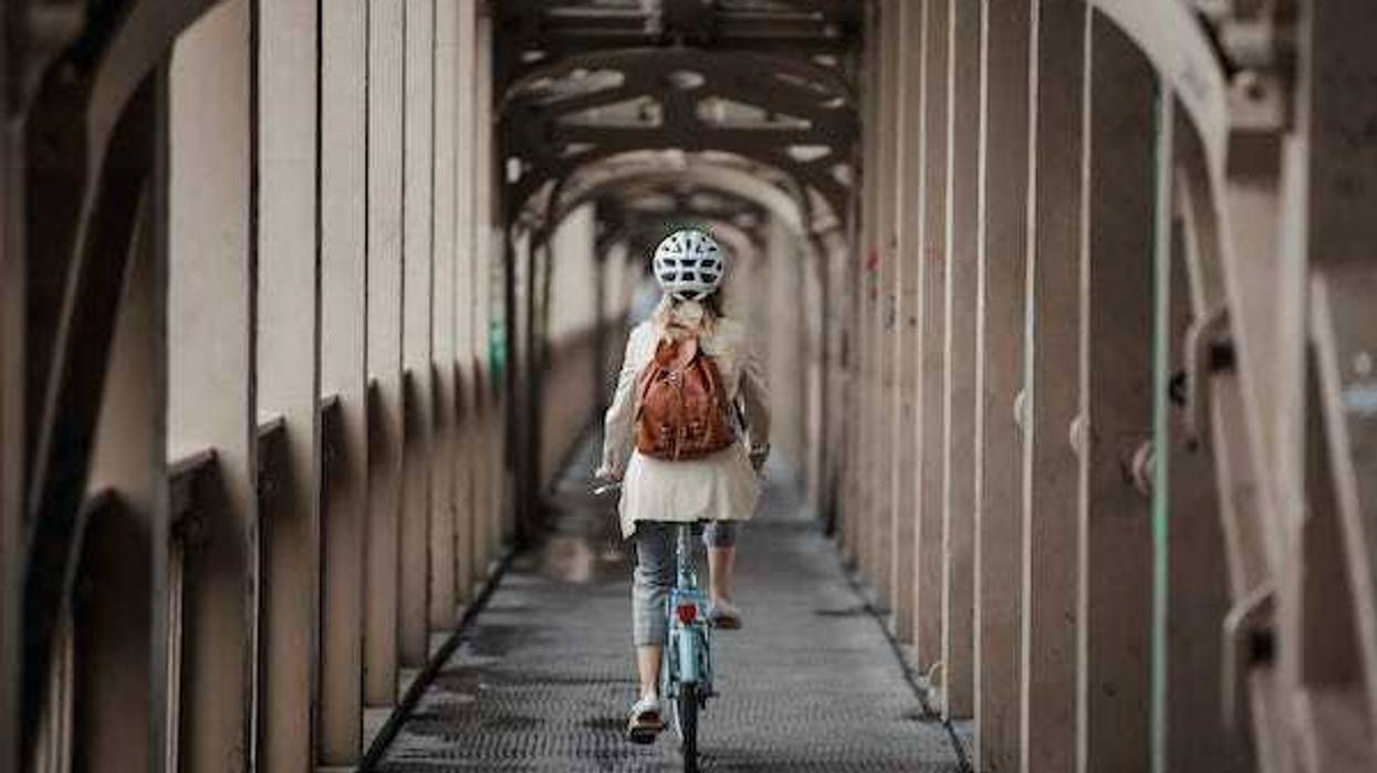 Woman cycling over a bridge