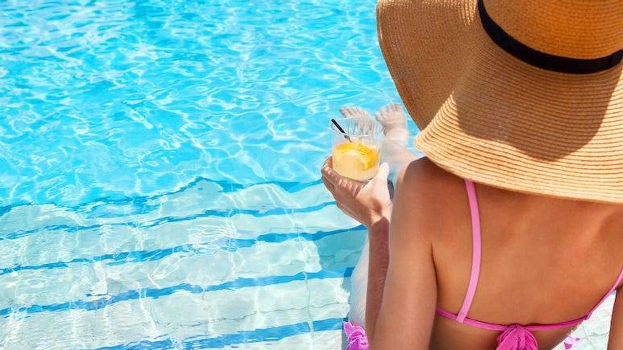 Woman drinking cocktail in pool
