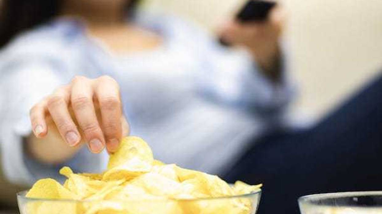 Woman eating a bowl of potato chips