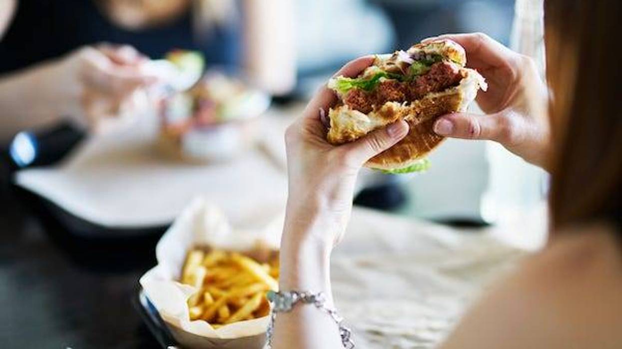 Woman eating a hamburger in a restaurant