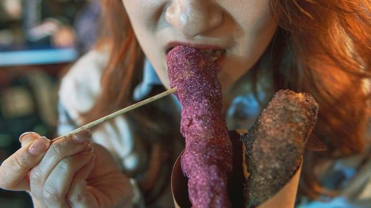Woman eating purple street food