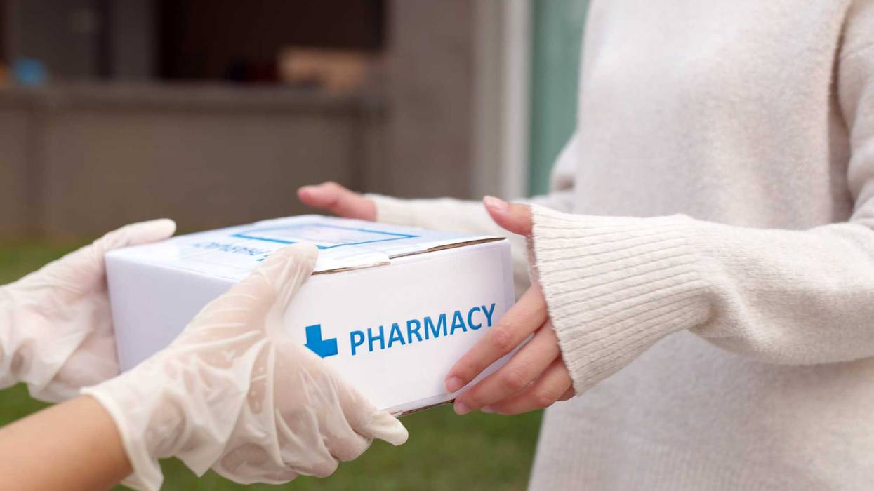 Woman getting a pharmacy delivery through the mail.