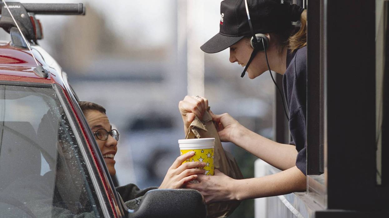 Woman handing off fast food to a customer